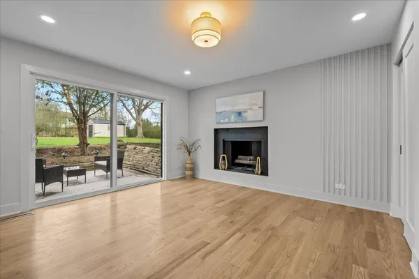 an empty room with fireplace wooden floor and outdoor view