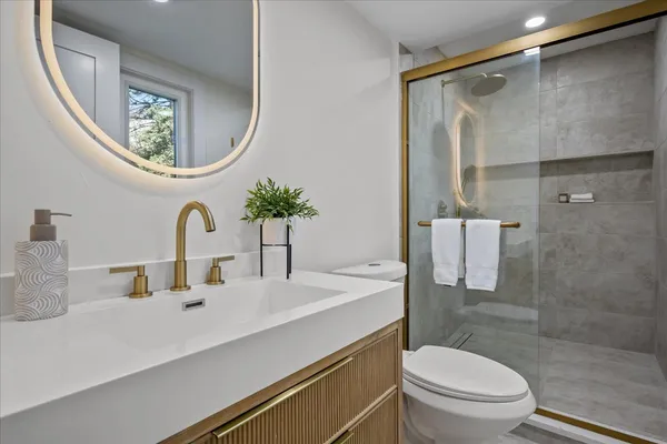 a bathroom with a toilet a sink and a mirror