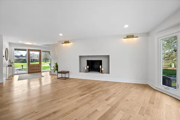 an empty room with wooden floor and fireplace