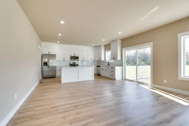 a view of a kitchen with a sink and dishwasher a refrigerator with wooden floor