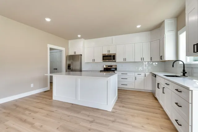 a kitchen with granite countertop white cabinets and white appliances