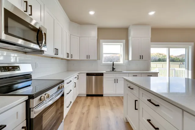 a kitchen with stainless steel appliances granite countertop a sink and stove top oven