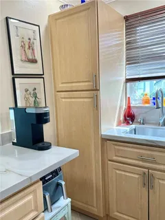 a view of a kitchen with refrigerator and wall