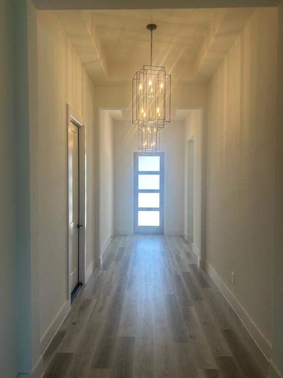 415 East Burks Street Pilot Point, TX 76258 - Photo 5 of 13 a view of a hallway with wooden floor and chandelier