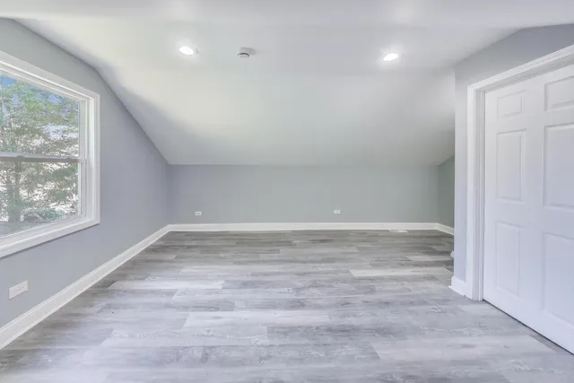 a view of empty room with window and wooden floor