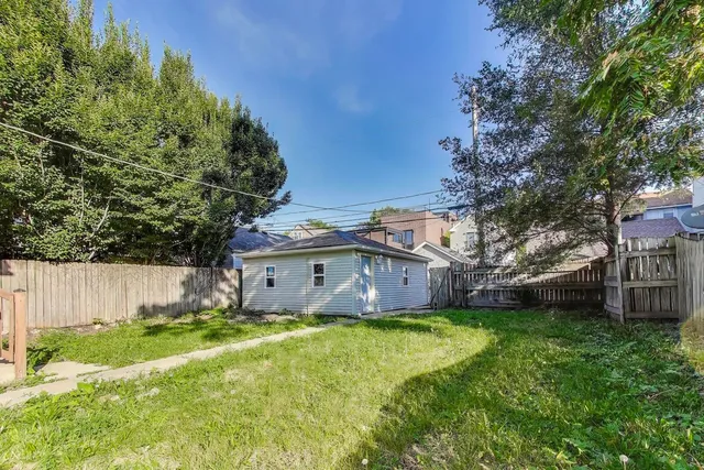 a view of a house with a big yard and large tree