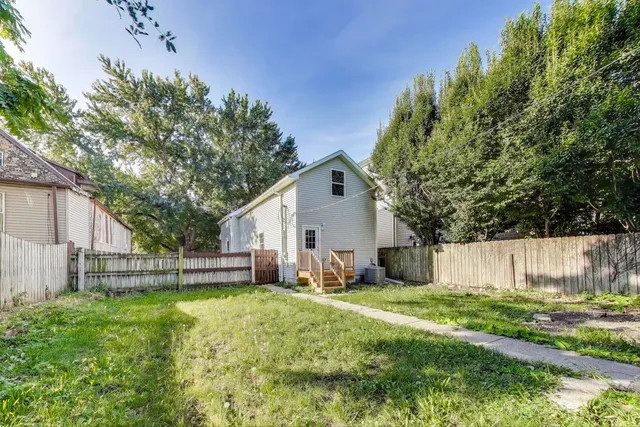a view of a house with backyard and a tree