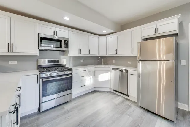 a kitchen with white cabinets and white appliances