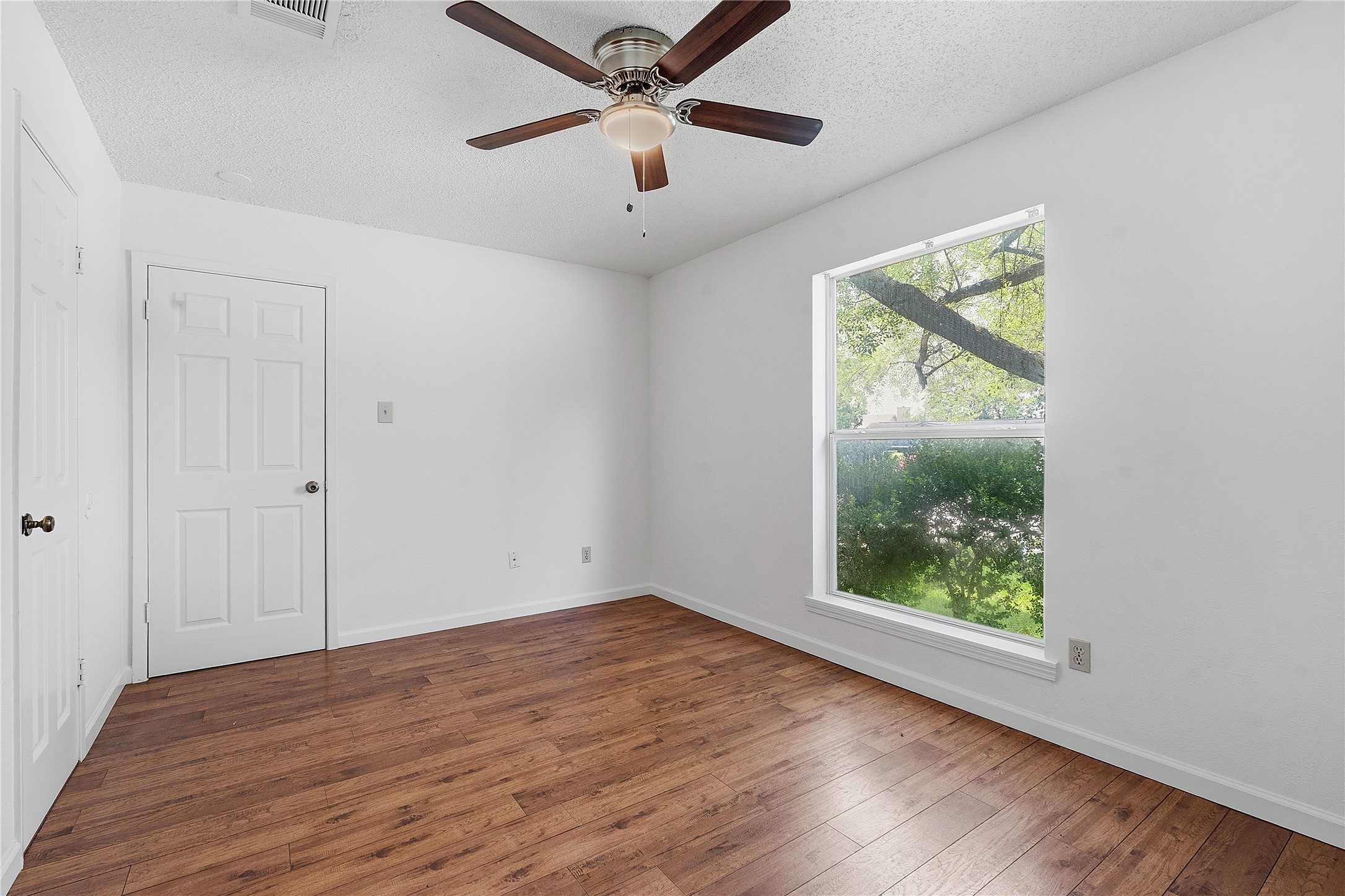 6205 Shadow Bend Austin, TX 78745 - Photo 20 of 31 A well-lit room featuring hardwood flooring and a ceiling fan for year-round comfort.