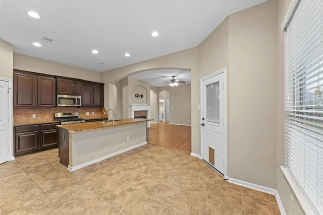 a large kitchen with kitchen island a sink stainless steel appliances and cabinets