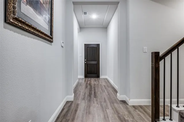 a view of a hallway with wooden floor and staircase