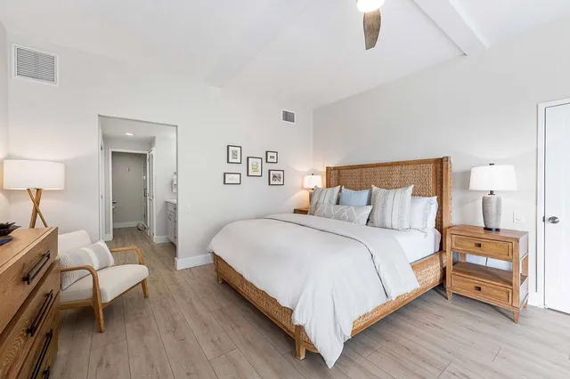 a bedroom with a bed and a wooden floor