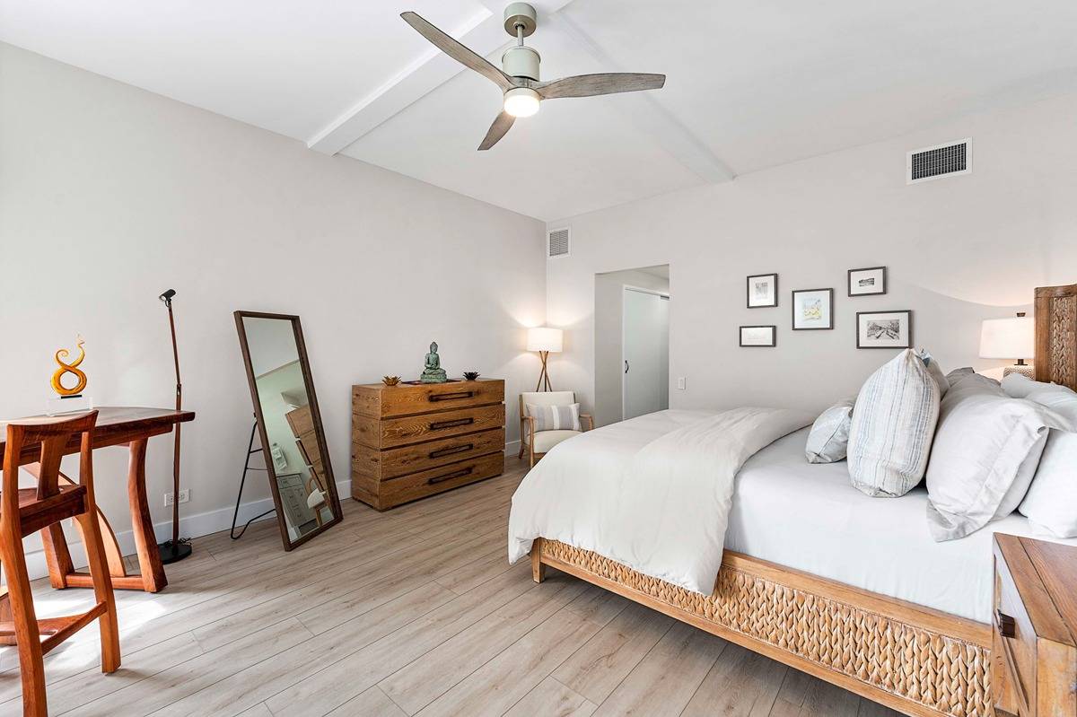 75-6040 Alii Drive, Unit 704 Kailua-Kona, HI 96740 - Photo 19 of 30 a bedroom with a bed and a table