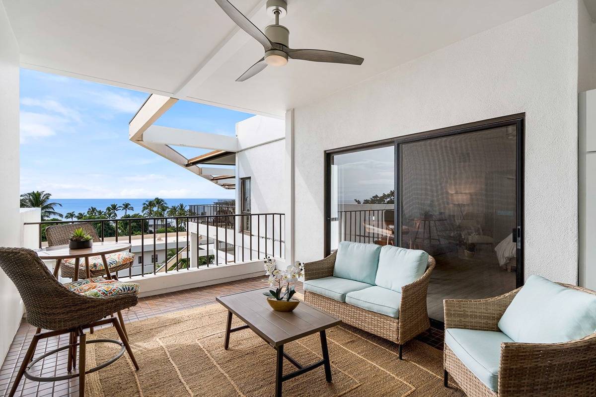 75-6040 Alii Drive, Unit 704 Kailua-Kona, HI 96740 - Photo 26 of 30 a living room with furniture and a floor to ceiling window