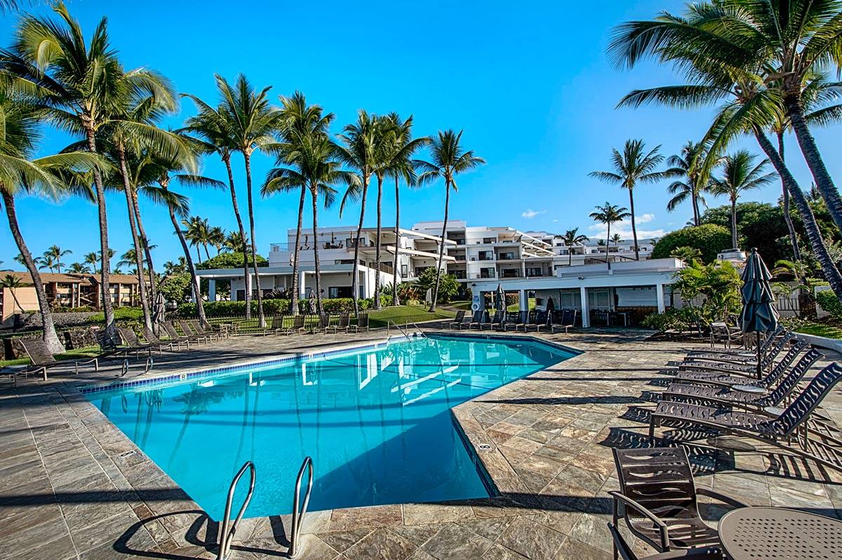 75-6040 Alii Drive, Unit 704 Kailua-Kona, HI 96740 - Photo 29 of 30 a view of a swimming pool with lounge chairs