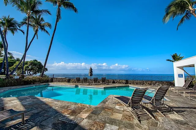 a view of a swimming pool with a patio and a yard