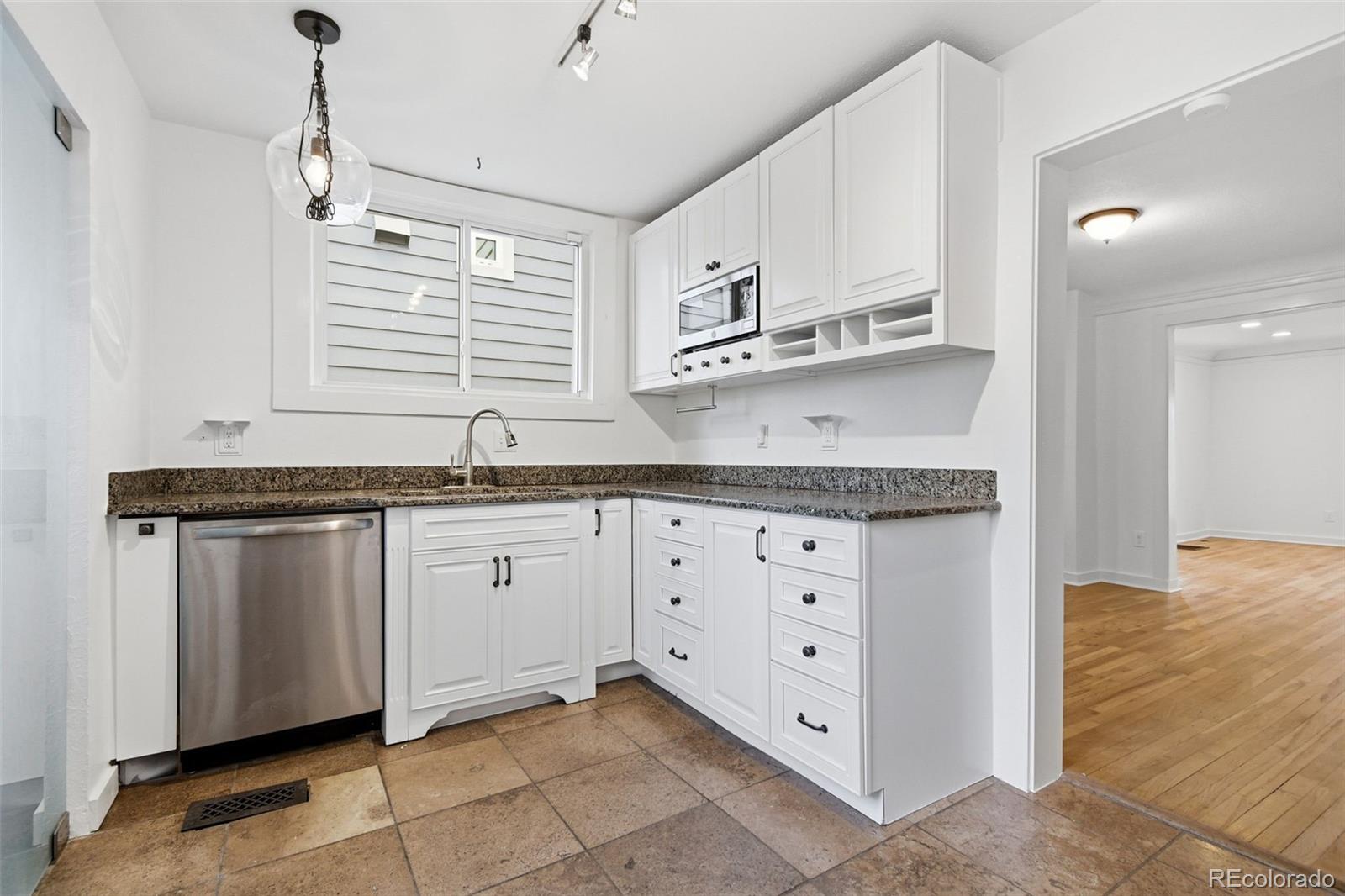 4182 Yates Street Denver, CO 80212 - Photo 16 of 48 a kitchen with stainless steel appliances granite countertop a sink and dishwasher a stove with white cabinets