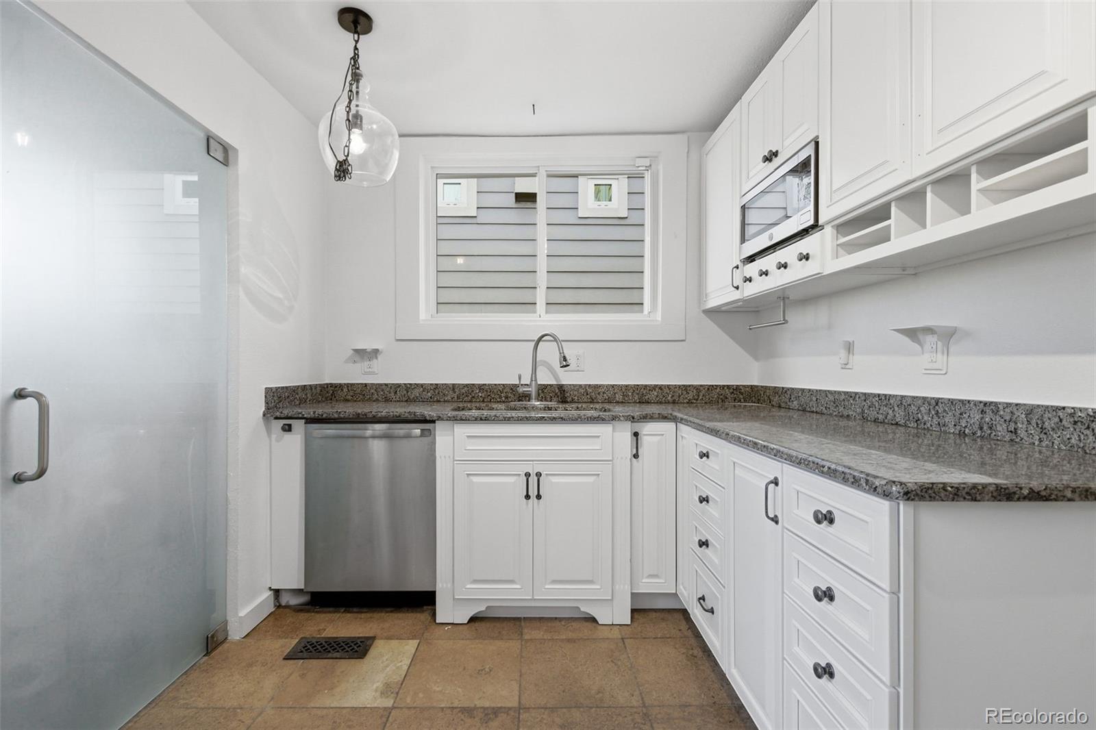 4182 Yates Street Denver, CO 80212 - Photo 17 of 48 a kitchen with granite countertop white cabinets and window