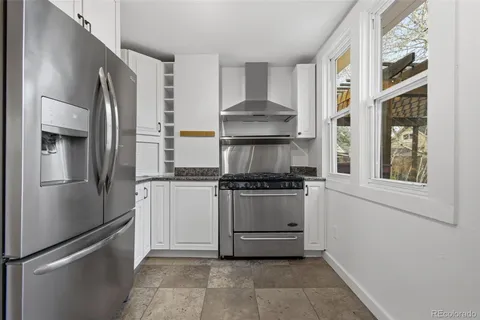 a kitchen with stainless steel appliances granite countertop a refrigerator and a stove