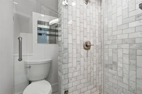 a bathroom with a toilet and a shower