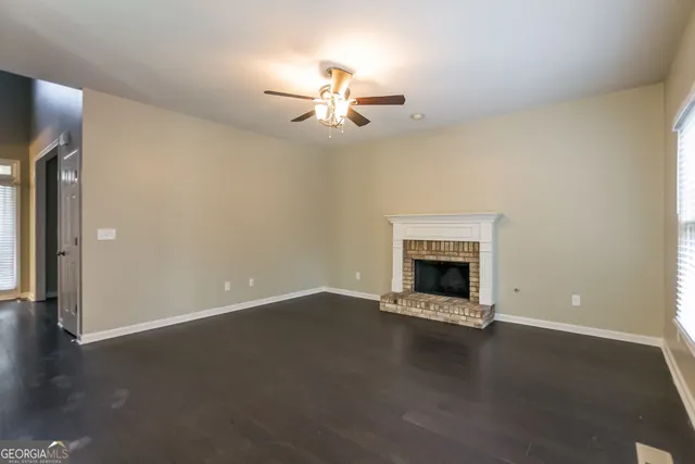 an empty room with a fireplace and wooden floor