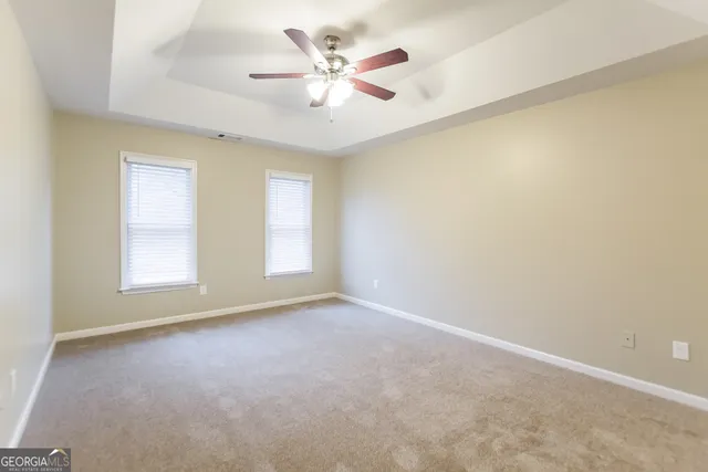 an empty room with a window and a ceiling fan