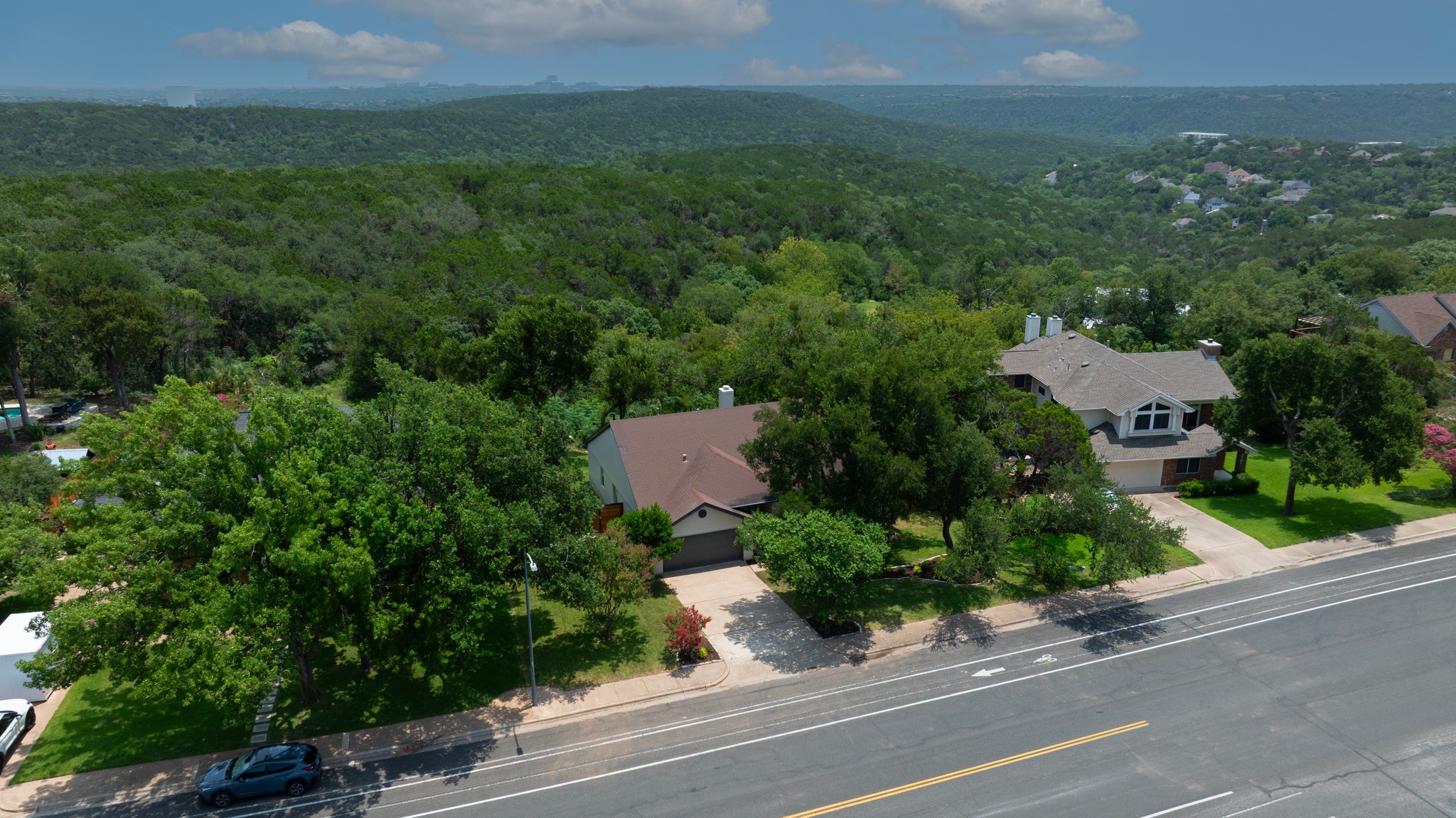 7705 Jester Boulevard Austin, TX 78730 - Photo 28 of 36 An aerial perspective reveals a private home nestled amidst a vibrant, green landscape.