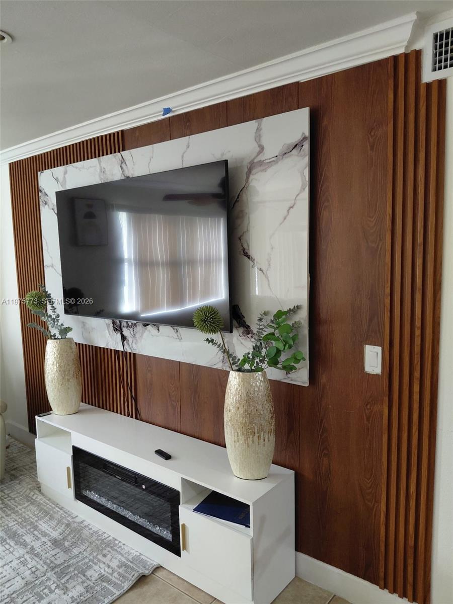 14915 Southwest 104th Street, Unit 2024 Miami, FL 33196 - Photo 2 of 34 a living room with a couch and a flat screen tv