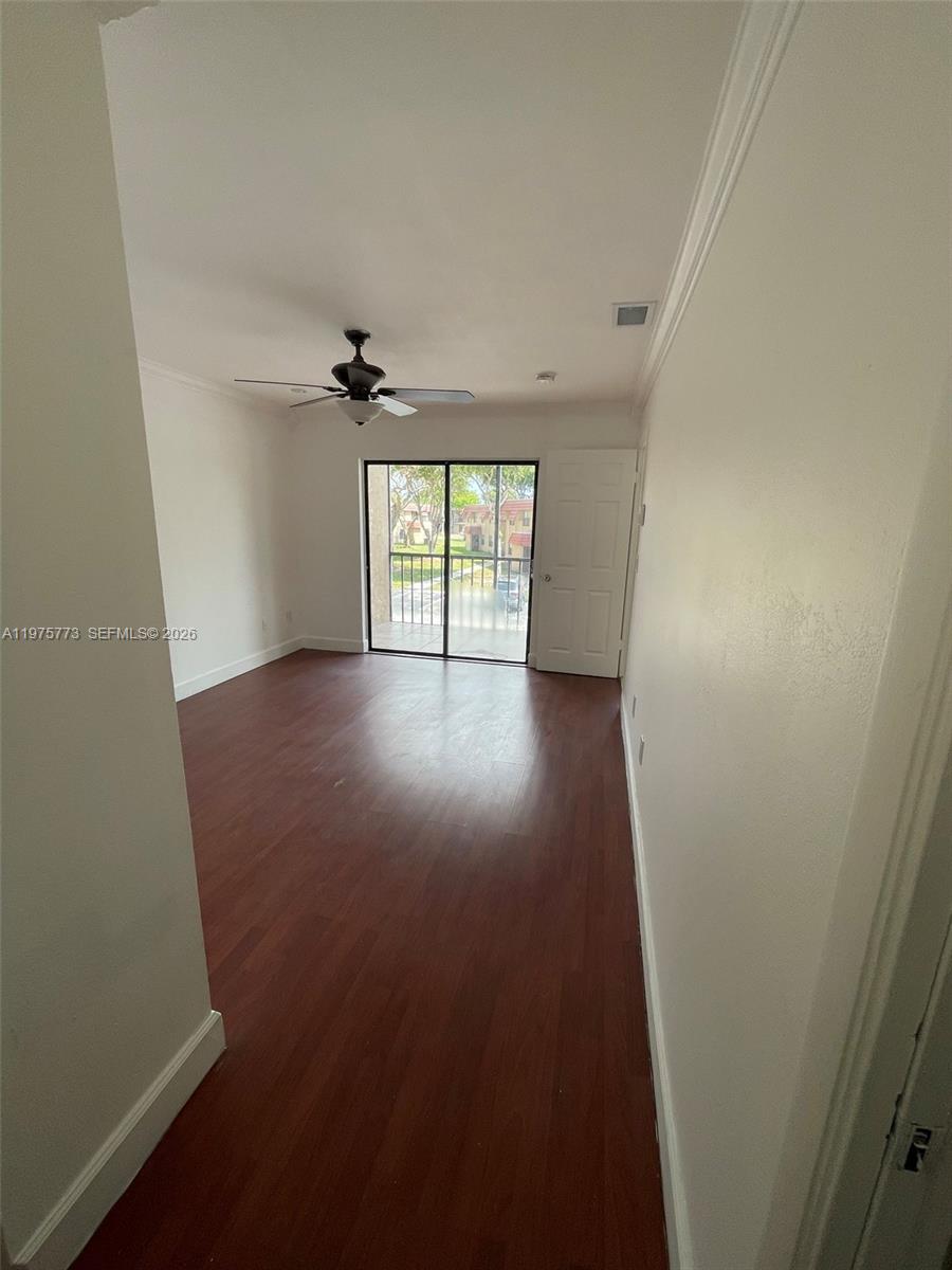 14915 Southwest 104th Street, Unit 2024 Miami, FL 33196 - Photo 21 of 34 an empty room with windows and a ceiling fan