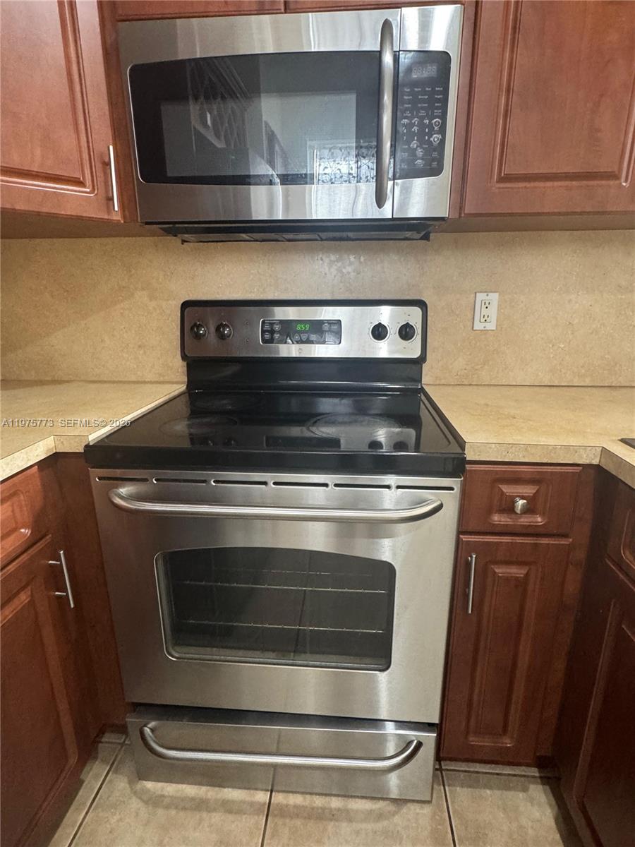 14915 Southwest 104th Street, Unit 2024 Miami, FL 33196 - Photo 5 of 34 a stove top oven sitting inside of a kitchen