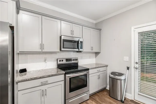 a kitchen with white cabinets stainless steel appliances and sink