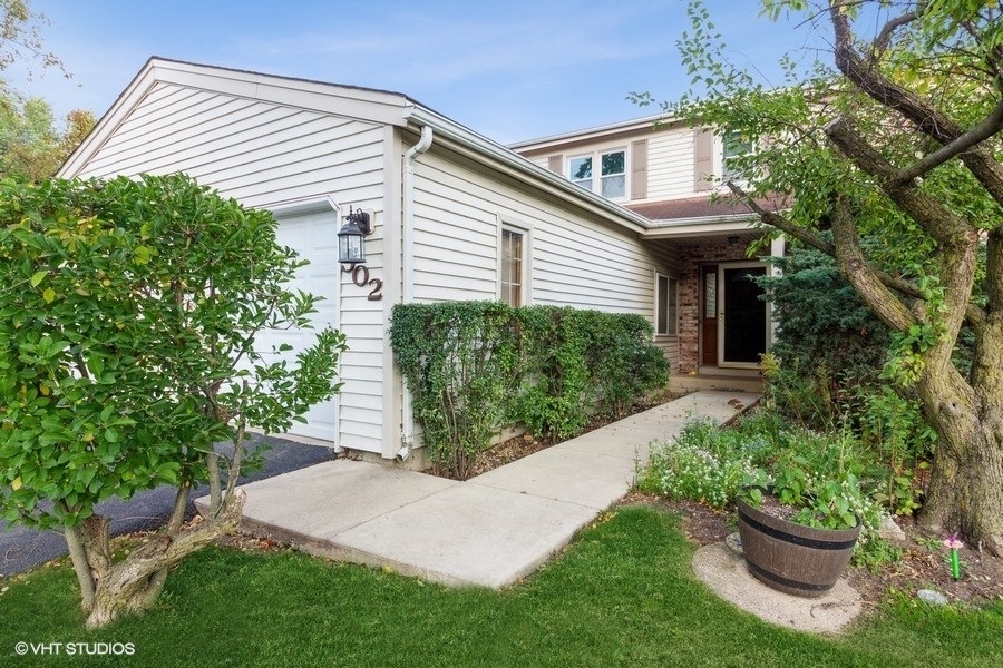 a front view of a house with a yard and potted plants
