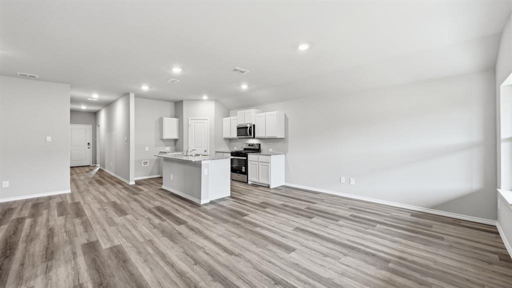 1632 Tin Roof Road Krum, TX 76249 - Photo 12 of 34 a view of kitchen with kitchen island wooden floors granite counter tops and white appliances