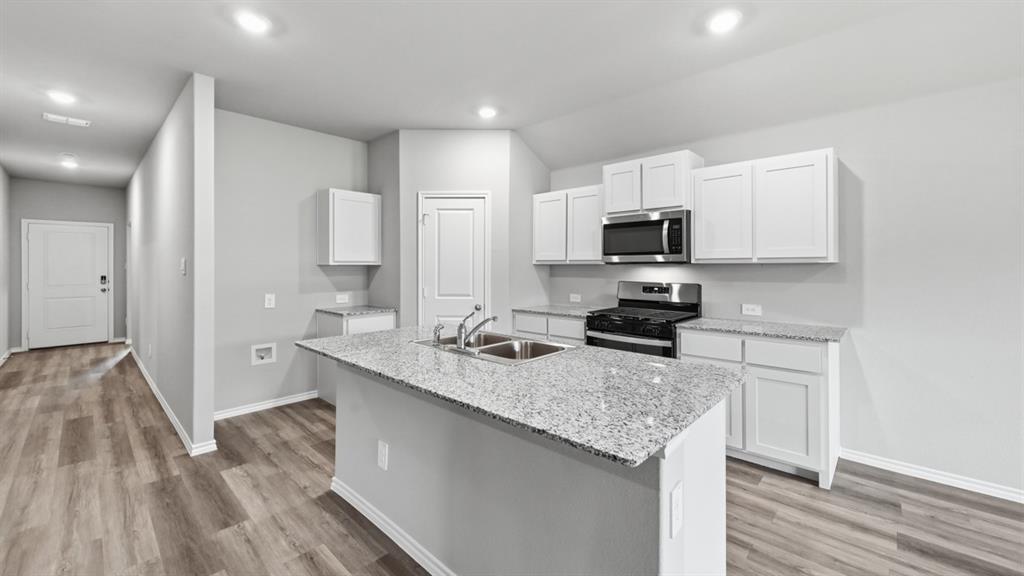 1632 Tin Roof Road Krum, TX 76249 - Photo 32 of 34 a kitchen with granite countertop a sink stove and refrigerator