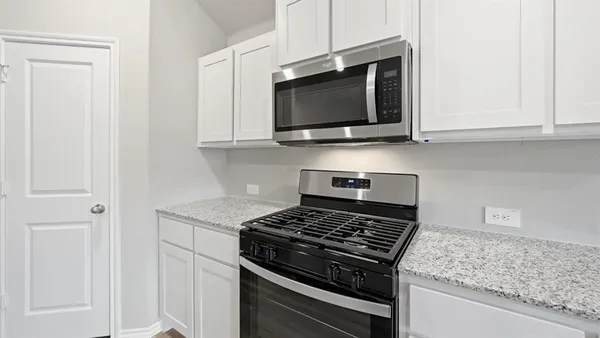 a kitchen with kitchen island granite countertop a sink stove and refrigerator