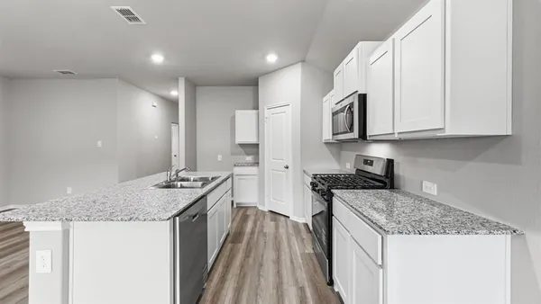 a kitchen with granite countertop a sink and a stove top oven