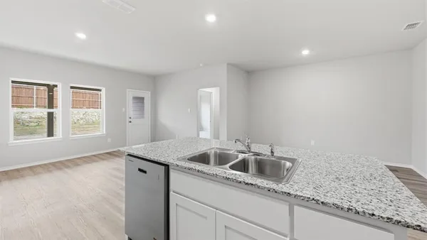 a kitchen with stainless steel appliances granite countertop white cabinets and a stove top oven
