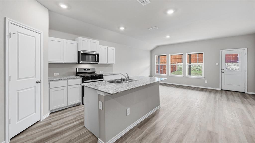 1632 Tin Roof Road Krum, TX 76249 - Photo 6 of 34 a kitchen with granite countertop a stove top oven a sink dishwasher and a refrigerator