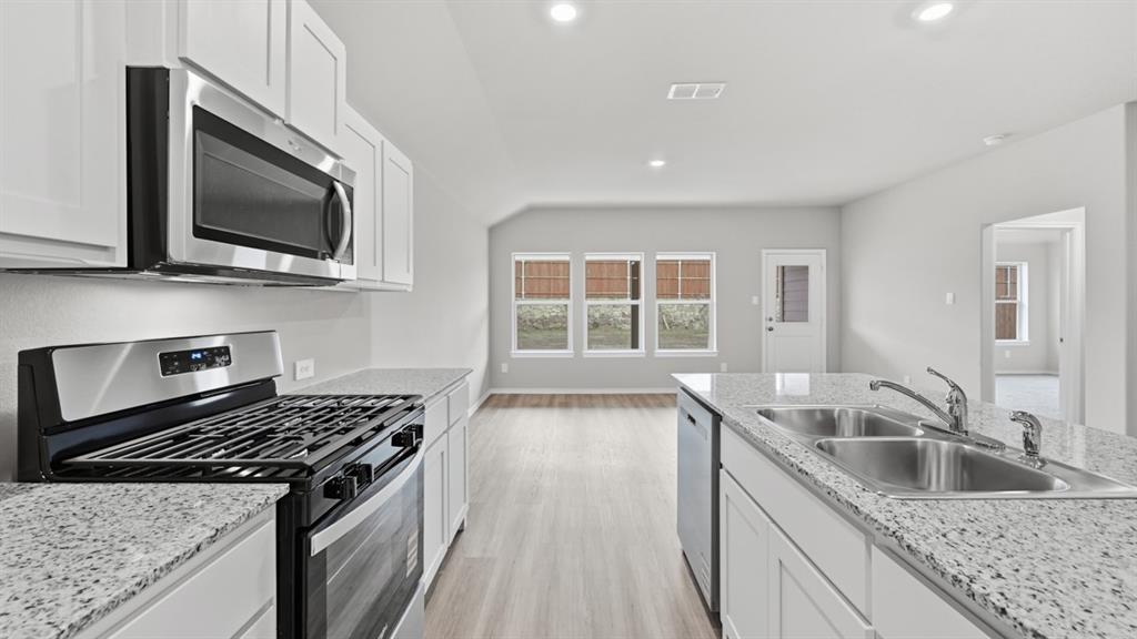 1632 Tin Roof Road Krum, TX 76249 - Photo 7 of 34 a kitchen with granite countertop a sink and a stove top oven