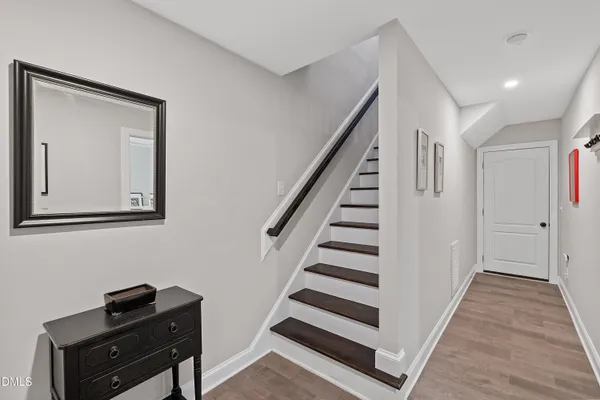 a view of hallway with stairs and wooden floor