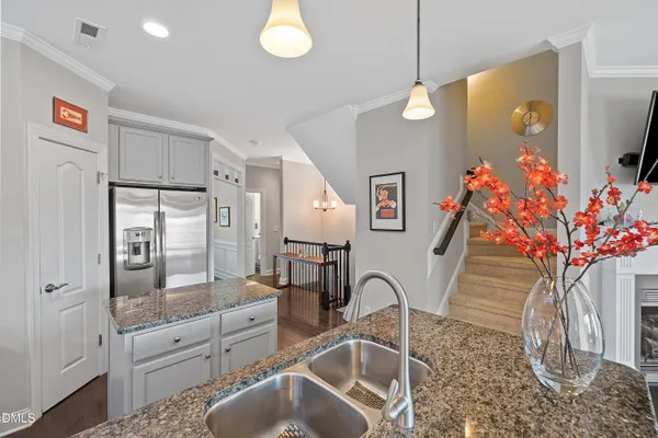a kitchen with kitchen island granite countertop a sink stove and refrigerator