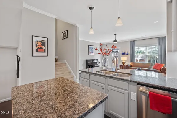a kitchen with stainless steel appliances granite countertop a refrigerator a sink dishwasher with a dining table and chairs