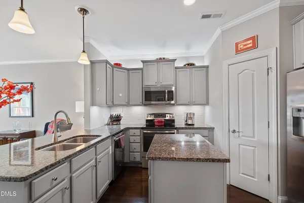 a kitchen with a sink cabinets and wooden floor