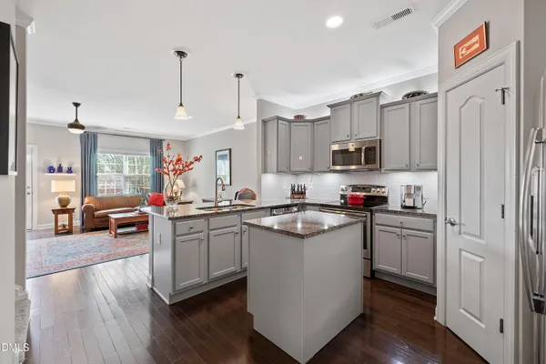 a kitchen with granite countertop white cabinets and refrigerator