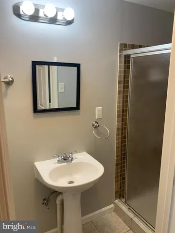 a bathroom with a sink mirror and shower