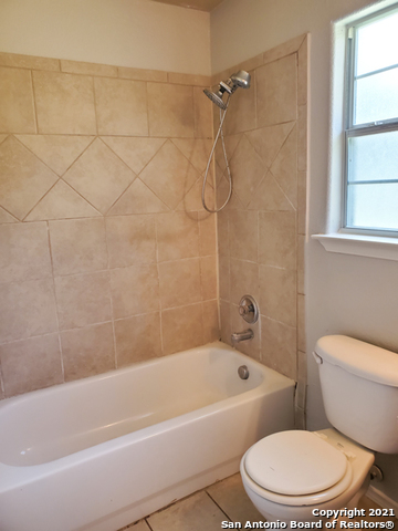 1431 Rivas Street San Antonio, TX 78207 - Photo 5 of 9 a white bath tub sitting next to a white toilet and a shower
