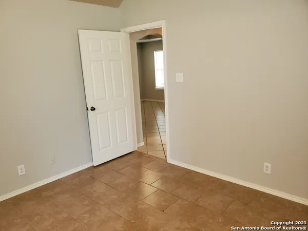 a view of an empty room with closet and mirror
