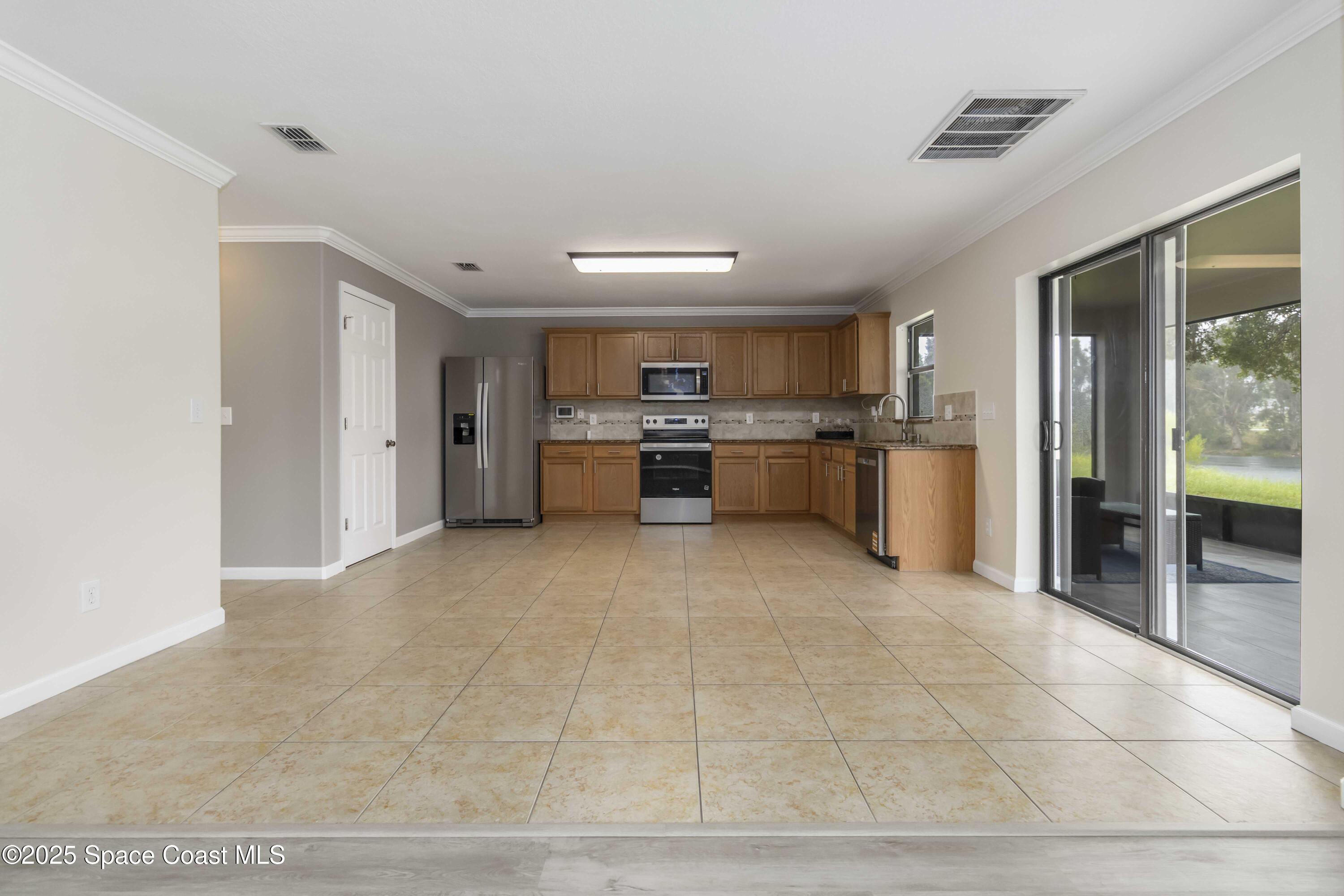 775 Russo Drive Melbourne, FL 32901 - Photo 7 of 29 a large kitchen with stainless steel appliances granite countertop a stove refrigerator and cabinets