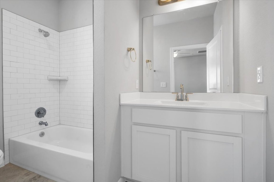 9015 Cattle Baron Path, Unit 1303 Austin, TX 78747 - Photo 12 of 29 a bathroom with a bathtub a sink a mirror and vanity