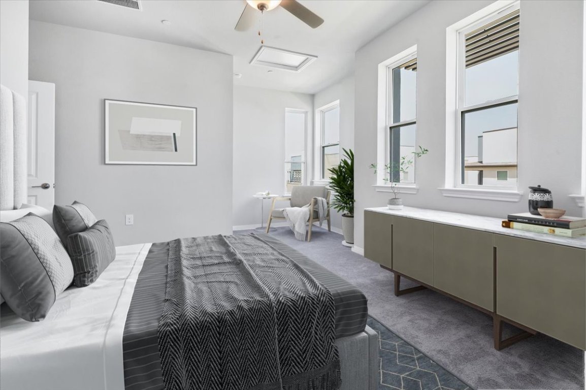 9015 Cattle Baron Path, Unit 1303 Austin, TX 78747 - Photo 15 of 29 a bedroom with a large bed and a chandelier